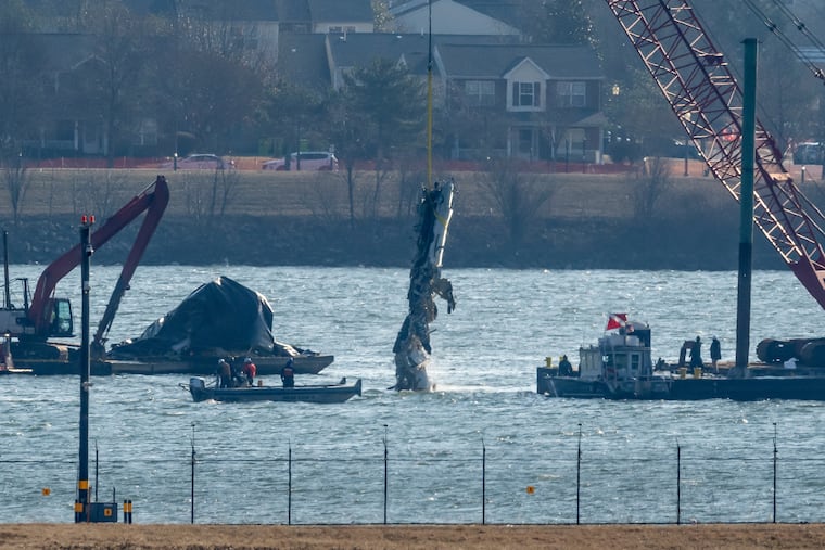 A piece of wreckage is lifted from the water onto a salvage vessel near the site in the Potomac River of a mid-air collision between an American Airlines jet and a Black Hawk helicopter Feb. 4, 2025, in Arlington, Va.