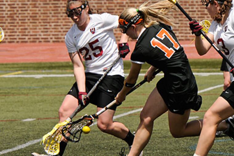 Princeton's Cassie Pyle picks up a loose ball from Harvard's Danielle Tetreault in the first period. (Ron Tarver/Staff Photographer)