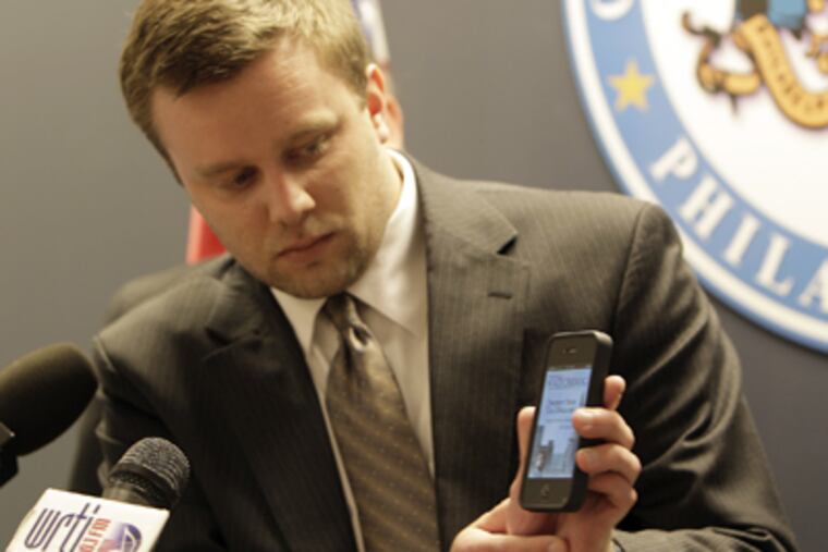 Brian Dries demonstrates on his iPhone as City Controller Alan Butkovitz announces the launch of Philadelphia's first fraud reporting app on Tuesday. (David Maialetti / Staff Photographer)