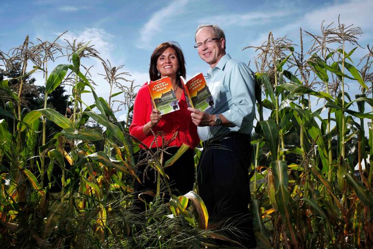 Farmers' Almanac editor Sondra Duncan and publisher Peter Geiger pose in a corn field with the 2012 edition of the almanac in this file photo. Its 2026 edition will be its last.