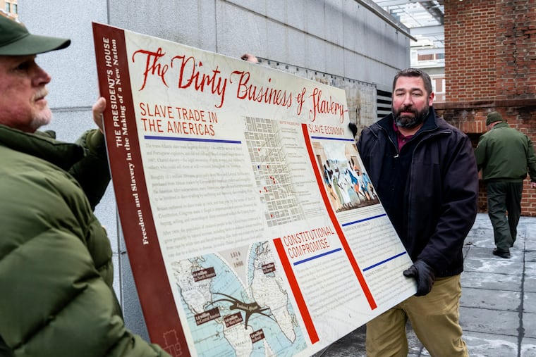 Workers remove displays that were part of a memorial to enslaved people at the President’s House site in Independence National Historical Park Thursday.