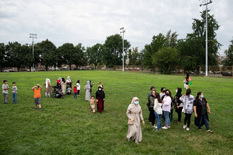 Women and children walk in the grass after a rally in solidarity with the people of Afghanistan and the Afghan community in Philly at Tarken Recreation Center in Northeast Philadelphia on Sunday, Aug. 22, 2021.