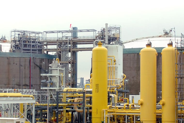 The PGW plant on Venango St. in Port Richmond. The two tall storage tanks in the background hold the liquified natural gas at a temperature of minus 260 degrees. The walls of the storage tank are approximately 15 feet thick. The four yellow towers in the foreground are "the expanders' where the natural gas (vapor form) is purefied of extraneous elements before being liquified. ( Clem Murray / Staff Photographer )
