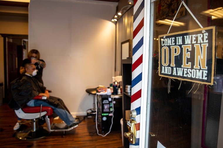 Nichole Missino, owner of Giovanni’s Media Barber Shop, has her door open for customers with appointments to get their haircut on Wednesday. “The governor isn’t really giving us a choice,” Missino said. “I’m opening to save my business here. My employees need to eat, they need to pay the bills, and keep the roof over their head.”