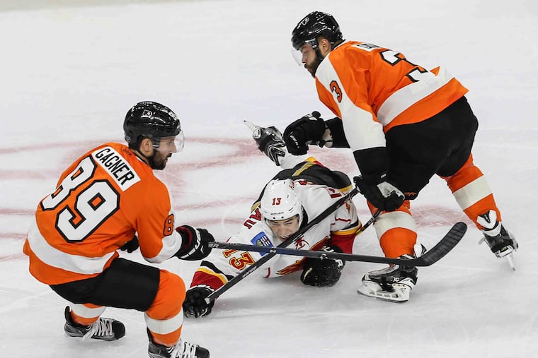 Flyers' Sam Gagner (89) and Radko Gudas surround Flames' Johnny Gaudreau during the first period at the Wells Fargo Center in Philadelphia, Monday, February 29, 2016.