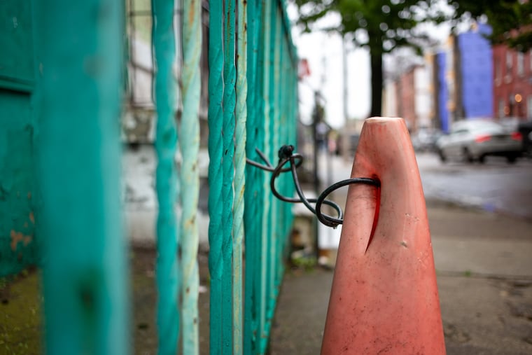 A traffic cone is secured to a fence near 26th and Oxford Streets in Brewerytown.