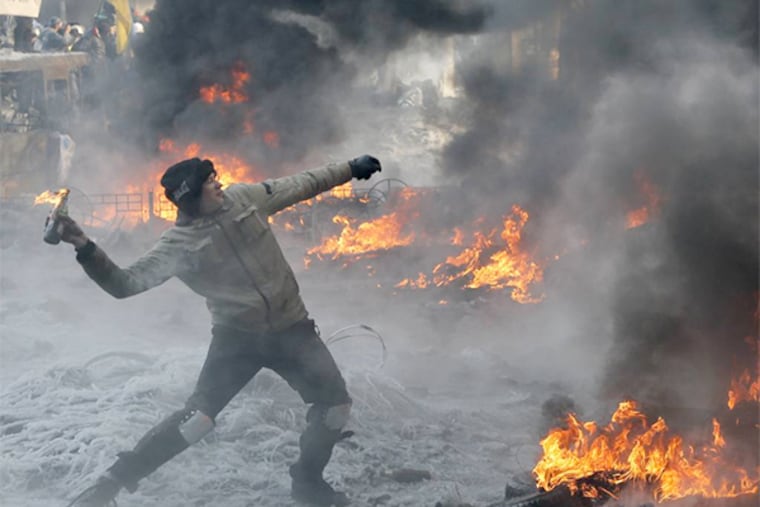 A protester throws a Molotov cocktail towards riot police during a clash in central Kiev, Ukraine, Saturday Jan. 25, 2014. Local Ukrainians and their supporters in Philadelphia will rally starting at the cultural center in Jenkintown at 2:30 p.m. on Sunday.