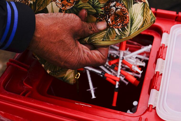 Keith Lewis disposes of used syringes at a needle exchange run by Camden Area Health Education Center in Camden, N.J., Thursday, Feb. 24, 2022. Four companies involved in the opioid industry are finalizing settlements over the addiction crisis in the U.S. in deals that could total $26 billion over 18 years.