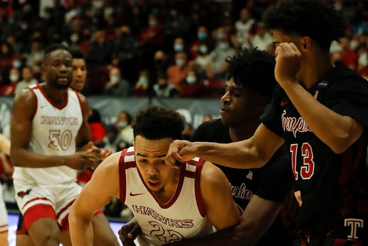Saint Joseph's Jordan Hall holds the ball while getting double-teamed by Temple's Jahlil White (center) and Tai Strickland during the second half on Saturday, December 11, 2021.