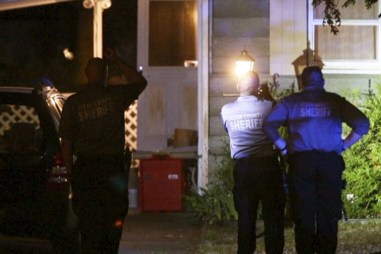 On Wednesday night, Aug. 16, 2017, Ocean County Sheriff’s Department CSI officers photograph the exterior of the Lacey Township home where authorities say a man killed his wife and child, then took his own life.