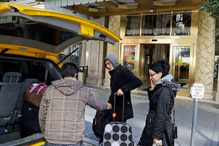Michael and Sabina Baugh, tourists from England, get into a taxi after checking out of the Cecil Hotel.