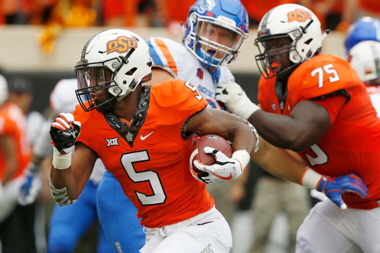 FILE - In this Sept. 15, 2018, file photo, Oklahoma State running back Justice Hill (5) runs past Boise State defensive end Durrant Miles, center, and teammate Marcus Keyes (75) and into the endzone with a touchdown in the first half of an NCAA college football game, in Stillwater, Okla. This season, four Big 12 backs are averaging at least 100 yards rushing per game in conference action. (AP Photo/Sue Ogrocki, File)