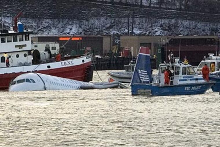 Rescue boats guide the US Airways plane that crashed into the Hudson River away from the original location of the incident. (Frank Franklin II/AP)