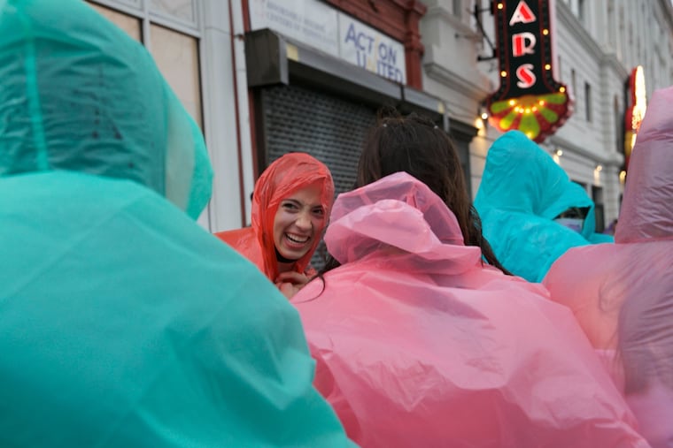 Fans wait in the rain and wind as they line up for the Olivia Rodrigo concert outside of the Met in North Philadelphia on Friday.