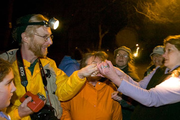 Kate Leader, a science teacher at Feltonville School of Arts and Sciences, takes a small green from from Doug Wechsler, of the Academy of Natural Sciences. (Ron Tarver / Staff Photographer)
