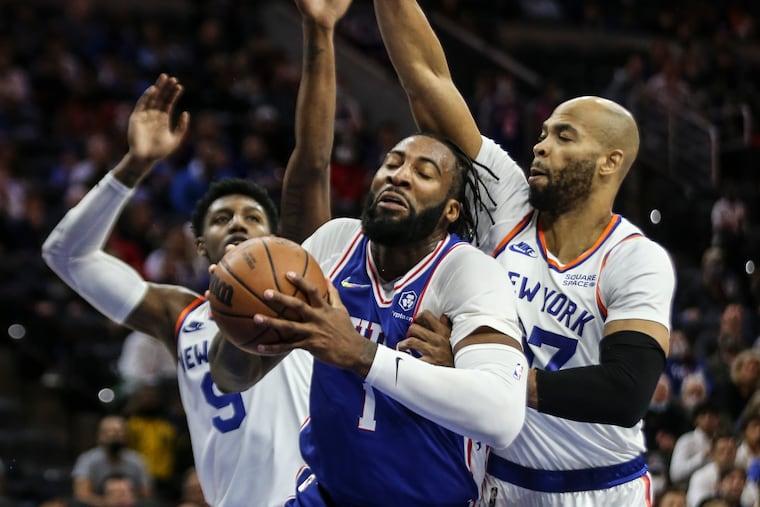 Sixers Andre Drummond goes up between Knicks RJ Barrett, left and Taj Gibson during the 1st quarter at the Wells Fargo Center in Philadelphia, Monday, November 8, 2021.
