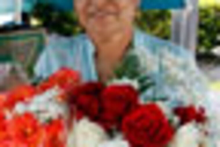 In this Friday, July 6, 2012 photo, Margarita Briones holds bouquets of flowers at her flower shop Margarita Flowers, in Miami. In cities like Miami, New York, Houston and Los Angeles, a small but growing group of mostly immigrant and minority entrepreneurs are turning to microfinancing. These loans, generally provided by nonprofit groups, can serve as stepping stones to more traditional sources of credit and are often the difference between success and failure for small business owners who may have nowhere else to turn for the money they need to build a business.(AP Photo/Lynne Sladky)