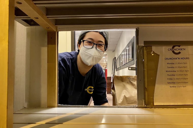 Jen Choi peeks through the service window in the door of Crunchik'n, 212 S. 11th St.
