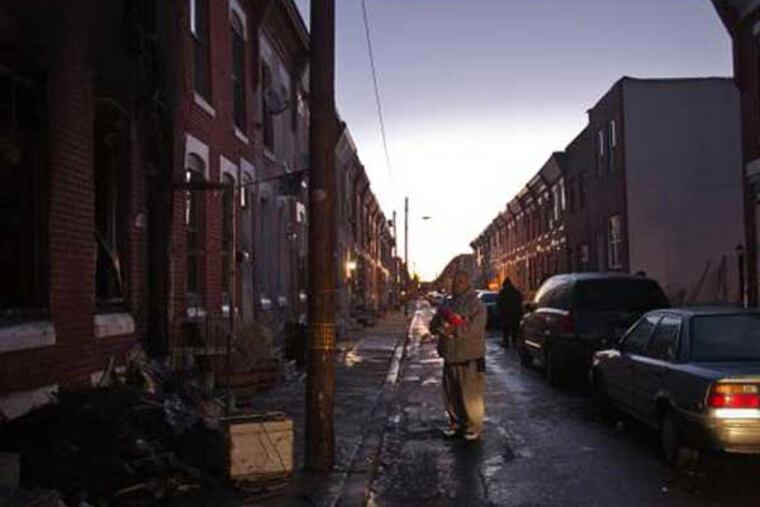 A family friend stands at the scene of a fire that killed two people on Daly Street in South Philadelphia on Thursday, Jan. 29, 2015. (Alejandro A. Alvarez / Staff)