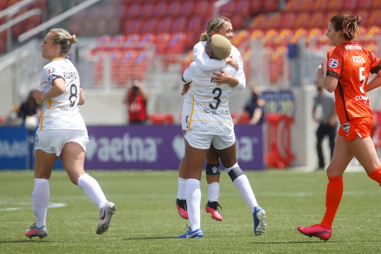 Sicklerville native Tziarra King (3) gets a hug from teammate Lo'eau LaBonta after scoring the tying goal in the Utah Royals' 3-3 tie with the Houston Dash.