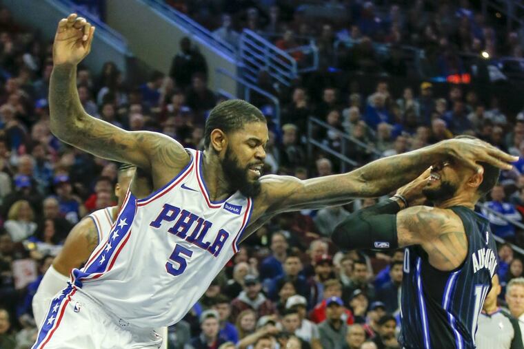 Sixers forward Amir Johnson (5) fouls Orlando guard D.J. Augustin during a Nov. 25 game. Fouling has become an issue for the Sixers.