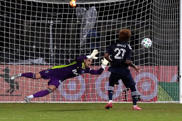 Sporting Kansas City forward Gianluca Busio (27) kicks the winning goal against Vancouver Whitecaps goalkeeper Thomas Hasal during a shootout in extra time of an MLS soccer match, Monday, July 27, 2020, in Kissimmee, Fla. (AP Photo/John Raoux)