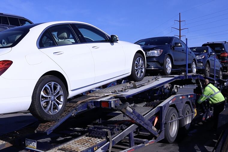 A worker loads vehicles onto a car transporter, a common sight at Manheim Auto Auction in Manheim, Pa. With a shortage of used vehicles in the post-COVID-19 economy, prices at the auction house have hit record highs.