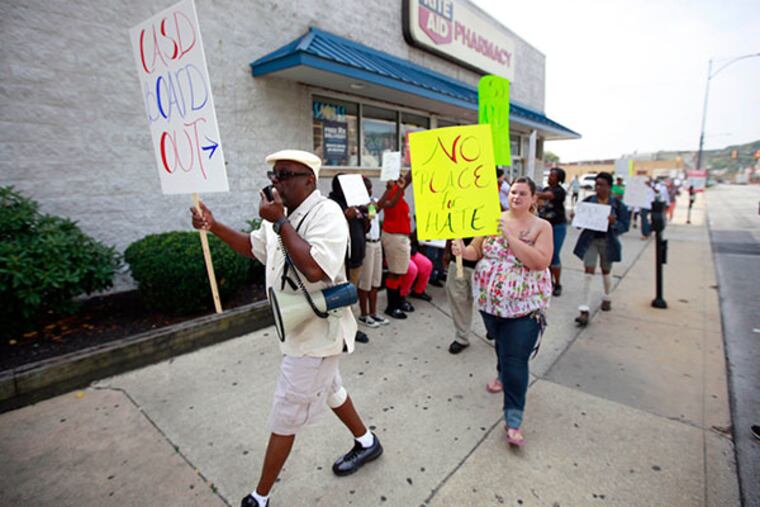 Lead by Fonz Newsuan (with megaphone), 30-plus people march on Lincoln Highway in Coatesville, protesting the school board, October 3, 2013. ( DAVID SWANSON / Staff Photographer )