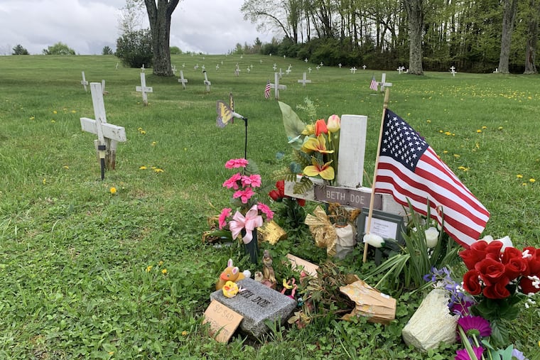 Flowers and sign mark the grave of Evelyn Colon and her unborn daughter, Emily Grace, at a Potter's Field in Carbon County, Pa. Authorities have charged a former boyfriend with homicide for 1976 murder.