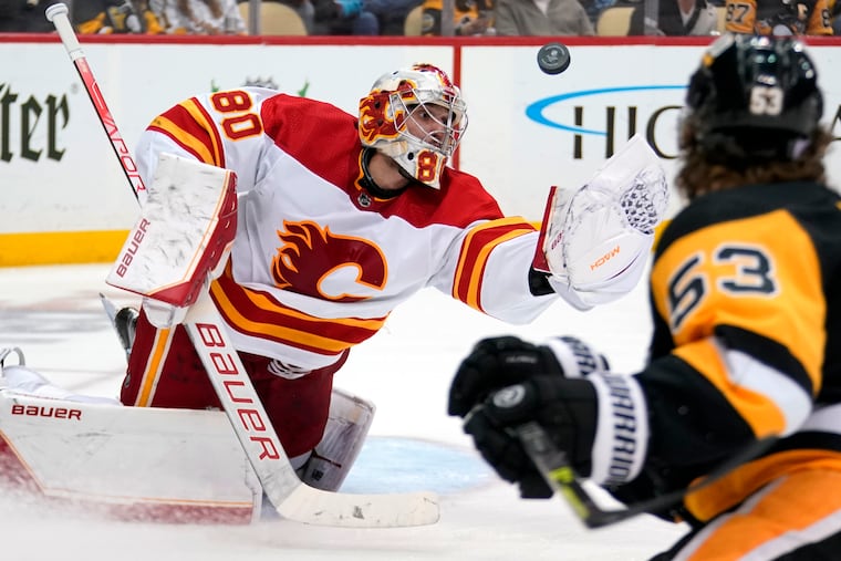 Calgary Flames goaltender Dan Vladar (80) reaches to glove the puck during the second period of the team's game against the Pittsburgh Penguins in Pittsburgh, Wednesday, Nov. 23, 2022. (AP Photo/Gene J. Puskar)