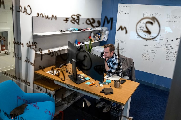Immunologist Daniel Claiborne writes on the glass walls at the Wistar Institute HIV Cure and Viral Diseases Center. The center is focused on finding a cure for HIV and other viral diseases.