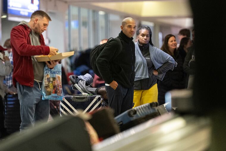 Travelers wait for their luggage at the Philadelphia International Airport in Philadelphia, Pa., Dec. 22, 2022.