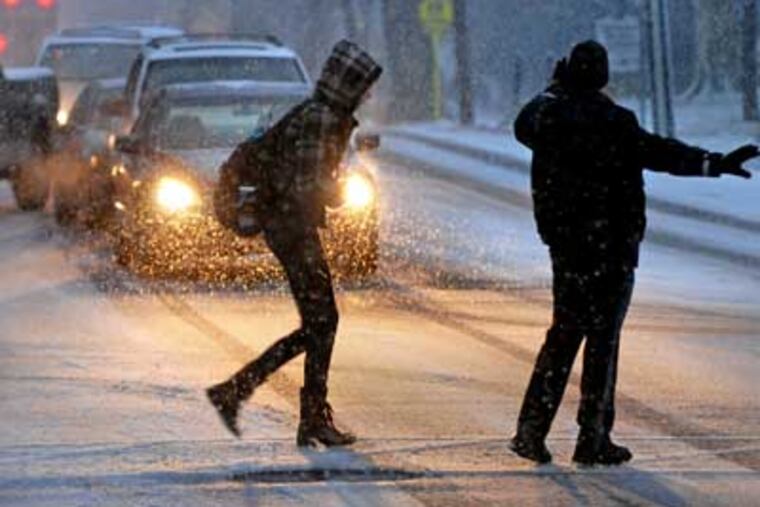 Haddonfield police officer Rich Walker stops traffic for students on Kings Highway near the high school as early morning snow began Jan. 7, 2011. ( Tom Gralish / Staff Photographer )