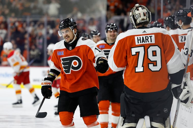 Flyers right wing Travis Konecny celebrates with goalie Carter Hart after scoring a shorthanded third-period goal against the Calgary Flames on Saturday.