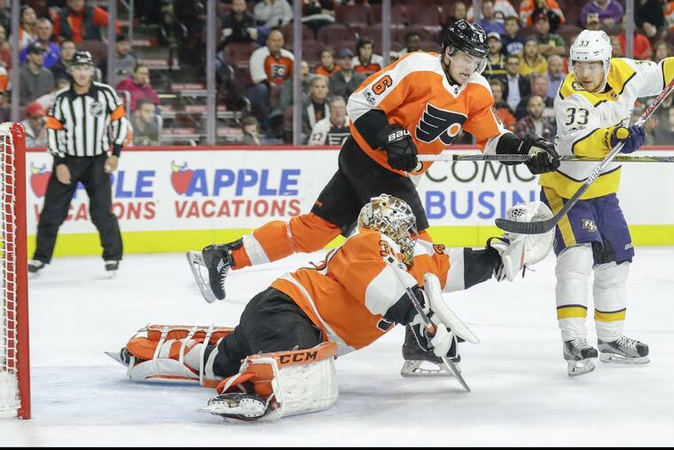 Flyers goalie Michal Neuvirth catches the puck with teammate Travis Sanheim by his side in Thursday’s 1-0 loss to visiting Nashville.