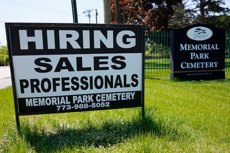 A hiring sign is displayed at a cemetery in Skokie, Ill., in early May.