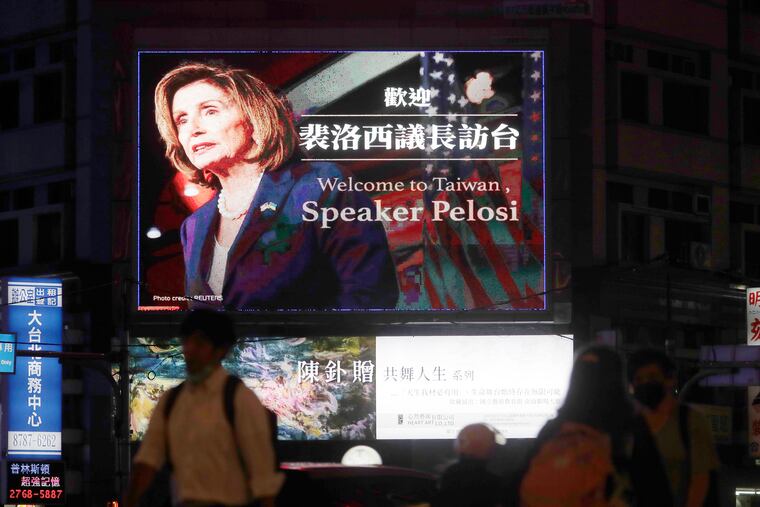 People walk past a billboard welcoming U.S. House Speaker Nancy Pelosi, in Taipei, Taiwan, Tuesday, Aug 2, 2022.