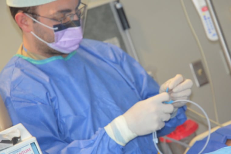 Cooper University Hospital physician Elird Bojaxhi prepares a central line catheter for insertion into a patient in the intensive care unit. ( Cooper
University Hospital )