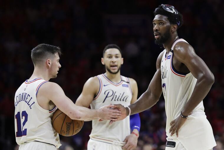 Sixers guard T.J. McConnell gives five to teammate Joel Embiid with Ben Simmons late in the fourth quarter against the Boston Celtics in Game 4 of the Eastern Conference semifinals on Monday, May 7, 2018 in Philadelphia.