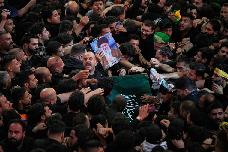 The coffin of the late Iranian Supreme Leader Ayatollah Ali Khamenei is carried through a tightly packed crowd as mourners jostle to reach and touch it outside the Imam Hussein Shrine in Karbala, Iraq, early Thursday, July 9, 2026.
