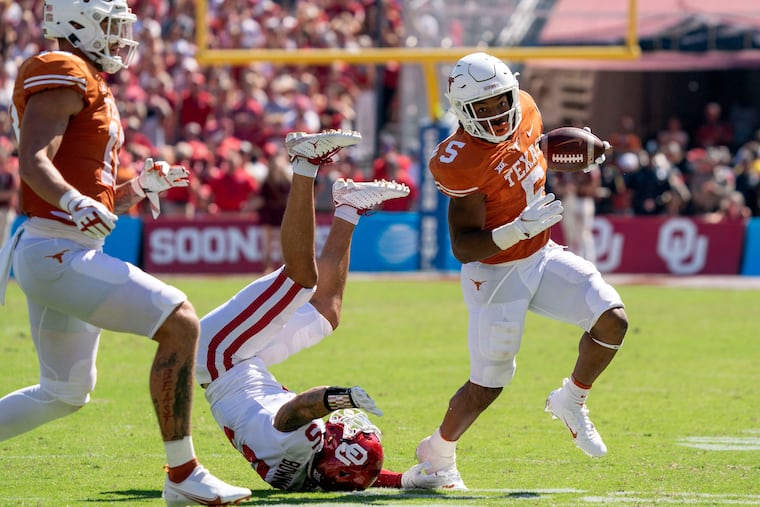 Texas running back Bijan Robinson runs past Oklahoma defensive back Billy Bowman.