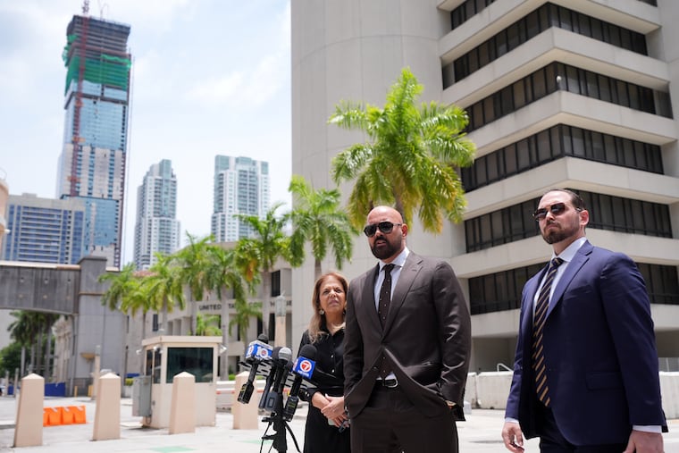 Attorneys Joseph McBride, center, and Jackie Perczek, left, represent Andrew and Tristan Tate as they fight extradition to the United Kingdom, where they are accused of rape and sex trafficking, speak to the media outside the C. Clyde Atkins U.S. Courthouse, Monday, July 27, 2026, in Miami.