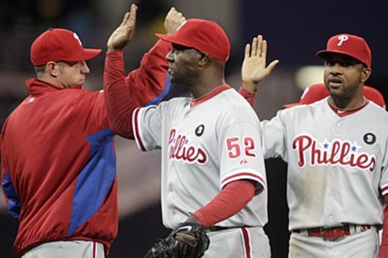 Jose Contreras, center, pitched a scoreless ninth inning to secure the Phillies' win on Thursday night. (Lenny Ignelzi/AP Photo)