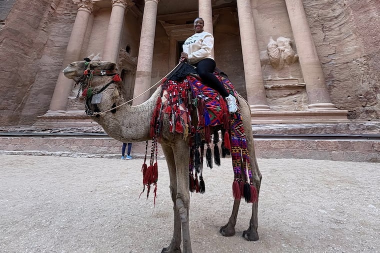 Mezgeron James, a Philadelphia travel agent, was in Jordan when the war broke out. She had to navigate her group of a dozen friends back home, including crossing by foot from Eilat, Israel, to Taba, Egypt. Here James is posing on a camel in the ancient city of Petra, Jordan, a UNESCO World Heritage Site.