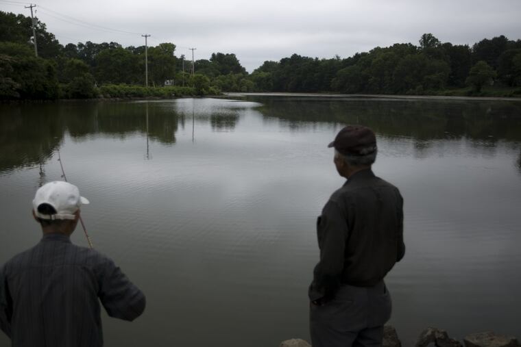 People fish at Milltown Dam in East Goshen Township July 6, 2017. Township officials voted to partially breach Milltown Dam, and there are plans for a smaller pond and trails there. ( MARGO REED / Staff Photographer )