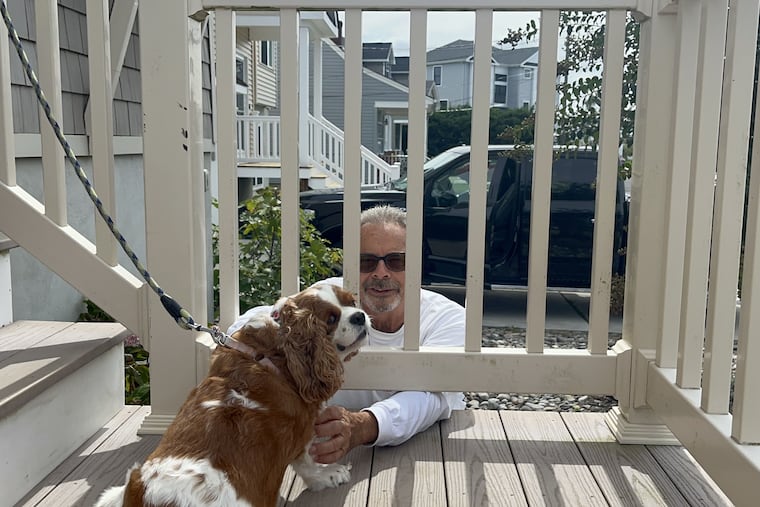 Robert Solari plays with his neighbor Laurel Haeser's dog on Cummings Place in Brigantine, N.J. Solari has rebuilt his house, and Haeser had hers raised, but she is selling. Both see big changes in Brigantine in the decade since Hurricane Sandy.