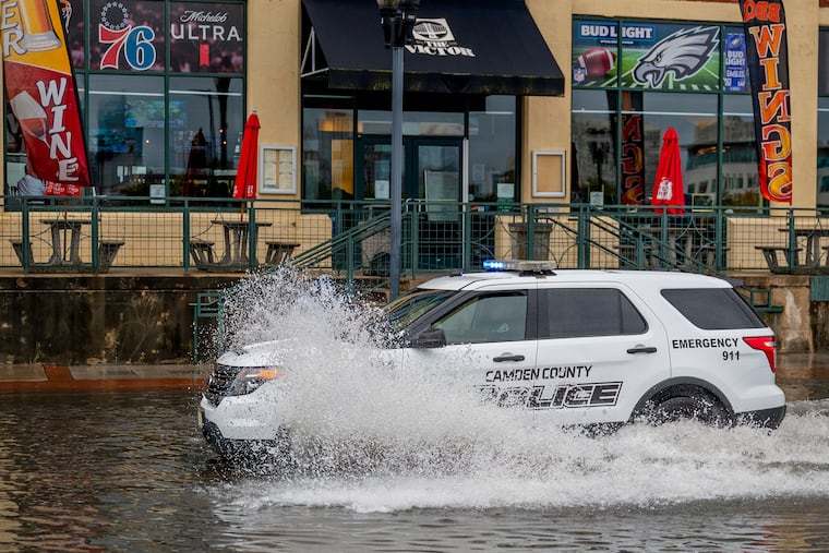 A Camden County Police cruiser passes through receding water near the Victor Pub along Delaware Avenue on the Camden Waterfront. Rains caused a whole lot of this on Thursday.