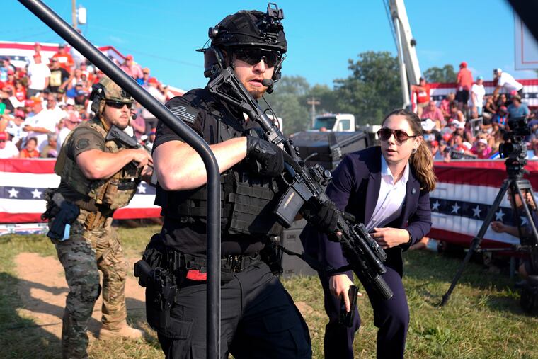 U.S. Secret Service agents respond as Republican presidential candidate former President Donald Trump is surrounded on stage at a campaign rally in Butler, Pa., on July 13, 2024.