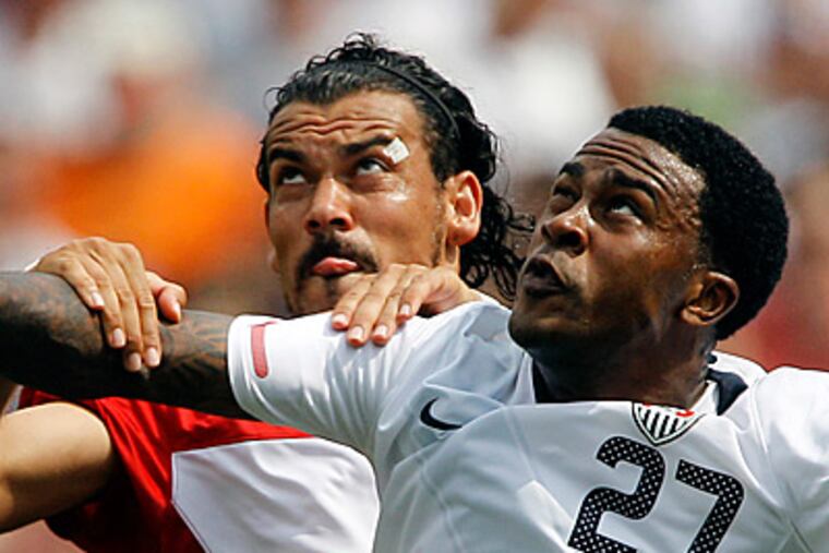 Turkey's Servet Cetin, left, and United States' Robbie Findley struggle for position on a header. (AP Photo/Matt Slocum)