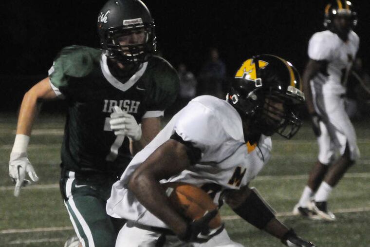 Moorestown's Sidney Ruffin picks up yardage in the third quarter; Camden Catholic's Nick Tretina gives chase. Ruffin had a kick-return TD for the Quakers. CURT HUDSON / For The Inquirer